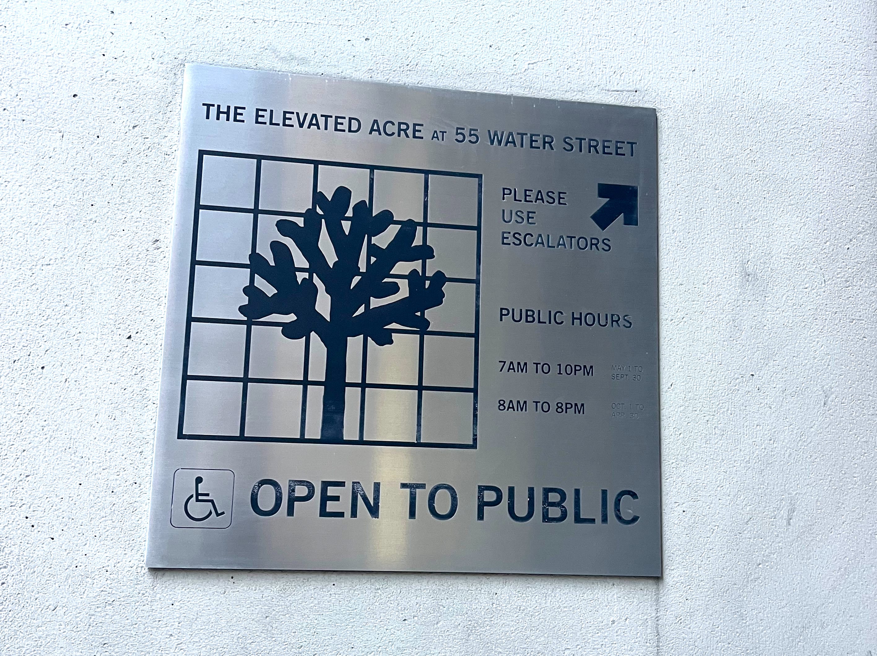 metal plaque sign for 55 Water Street showing POPS logo of a tree on a grid