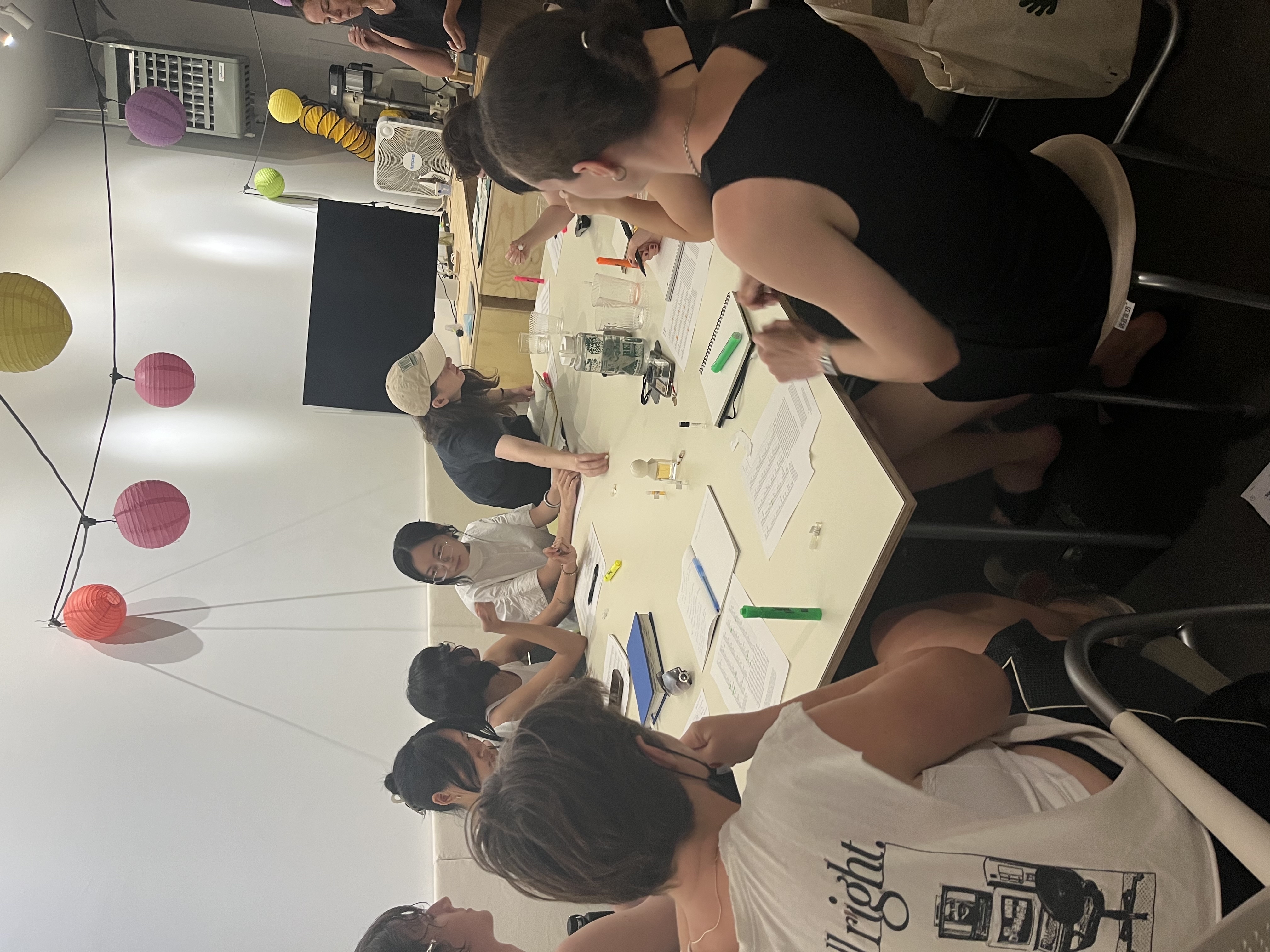 participants sit around a
table smelling tiny vials of perfume samples