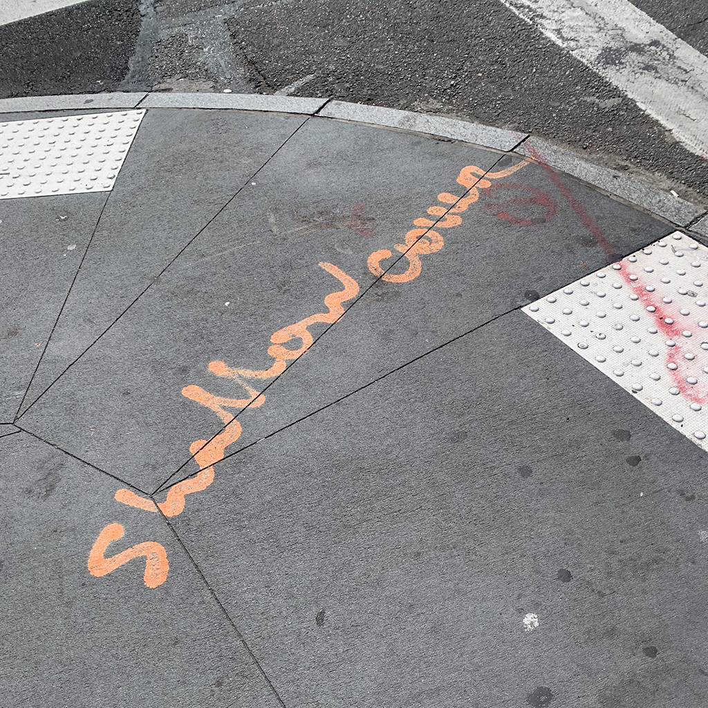 'shallow cover' written in cursive orange spraypaint on NYC street